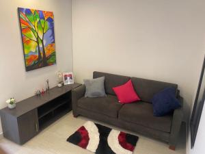 uma sala de estar com um sofá castanho com almofadas coloridas em Centro Internacional - La Quinta em Bogotá