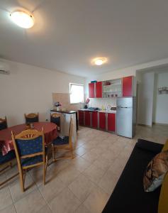 a kitchen with a table and a kitchen with red cabinets at Apartments by the sea Cove Pjestata, Peljesac - 10210 in Janjina