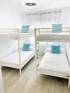 um quarto com 3 beliches com almofadas azuis em Blue house 1ª linea playa em Torrevieja