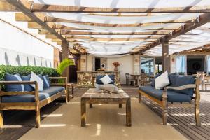 a patio with two chairs and a table and a pergola at Villa Rasa in Búzios