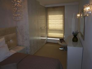 a small bedroom with a bed and a window at Apartament Sea Towers in Gdynia