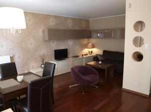 sala de estar con mesa y silla púrpura en Apartament Sea Towers, en Gdynia