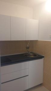 uma cozinha com um lavatório e armários brancos em Apartments with a parking space Pisak, Omis - 4281 em Mimice