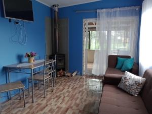 Sala de estar azul con sofá y mesa en CABAÑA OSORNO Ruta 215 en Osorno