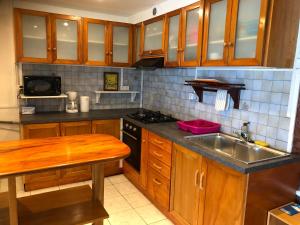 a kitchen with wooden cabinets and a sink at Magnifique F3 tout équipé in Papeete