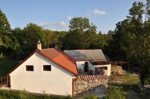 ein altes weißes Haus mit einer Steinmauer in der Unterkunft Secluded holiday house Stokic Pod, Velebit - 21524 in Jablanac