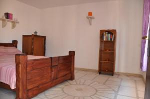 a bedroom with a wooden bed and a book shelf at Secluded holiday house Stokic Pod, Velebit - 21524 in Jablanac