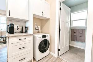 a white laundry room with a washer and dryer at RainCoast Retreat at Shawnigan Lake! in Shawnigan Lake