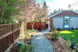 un patio trasero con una valla y una casa en RainCoast Retreat at Shawnigan Lake! en Shawnigan Lake