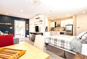 a bedroom with a bed and a kitchen with a table at RainCoast Retreat at Shawnigan Lake! in Shawnigan Lake