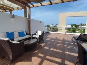 a patio with chairs and a couch on a balcony at Cortesito santana in Punta Cana