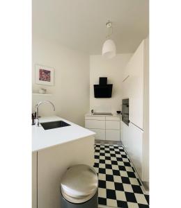 een keuken met een zwart-wit geruite vloer bij ApartmentInCopenhagen Apartment 1550 in Kopenhagen
