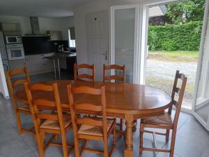 einen Holztisch und Stühle in der Küche in der Unterkunft Jolie villa 20min de Lourdes in Asson