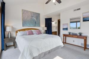 a bedroom with a large white bed and a table at Heron Way in Osage Beach