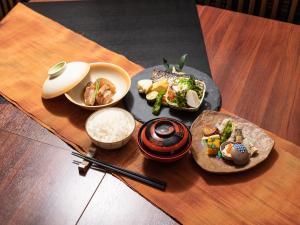a table topped with plates of food and rice at Seaside Hotel Kujukuri in Sanmu