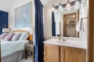 a bathroom with a sink and a bed and a mirror at Heron Way in Osage Beach