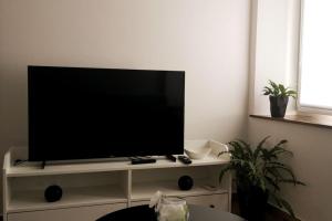 een flatscreen-tv zittend op een wit entertainment center bij Lovely apartment Morje - Koper old town in Koper