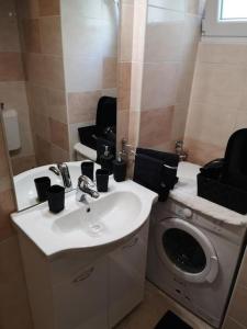 a bathroom with a sink and a washing machine at Lovely apartment Morje - Koper old town in Koper +8 photos