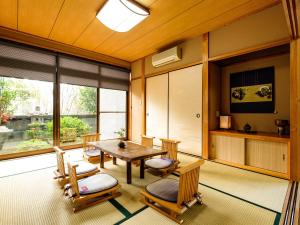 een kamer met een tafel en stoelen en een groot raam bij Yanagi-an in Kameoka