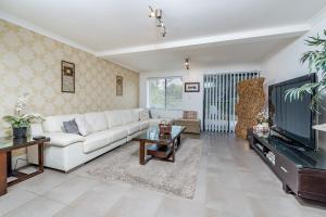 a living room with a white couch and a tv at Swan Valley in Upper Swan