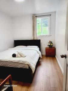 - une chambre avec un lit avec un animal rembourré dans l'établissement Beautiful Maple ridge farm cabin unit A, à Maple Ridge