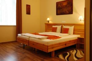 1 dormitorio con cama de madera en una habitación en Manzard Panzio, en Budapest