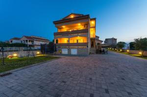 uma casa grande com uma entrada de tijolos em frente em Apartments Škara em Bibinje