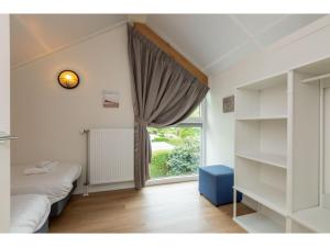 een slaapkamer met een raam en een bed bij Detached holiday home in a wooded area near the beach in Burgh Haamstede