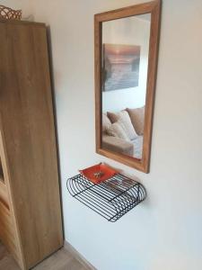 a mirror sitting on a wall next to a shelf at Rannarajooni holiday apartment in Pärnu