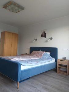 a bedroom with a blue bed and a wooden cabinet at Rannarajooni holiday apartment in Pärnu