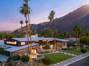 a house with palm trees and mountains in the background at Del Marcos Hotel, A Kirkwood Collection Hotel in Palm Springs