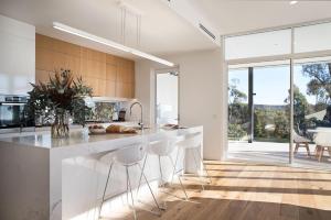 a kitchen with a large white island with stools at Barwidgee in Hepburn Springs