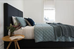 a bedroom with a bed and a table with a book at Barwidgee in Hepburn Springs