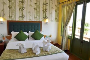 a bedroom with a bed with two stuffed animals on it at Mountain Club Resort Munnar in Chinnakanal