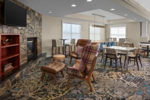 a living room with a fireplace and a table and chairs at Residence Inn Manassas Battlefield Park in Manassas