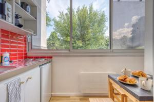 a kitchen with a window and a table with bread at Le Taillefer 1 - Louis XIV in Rhut