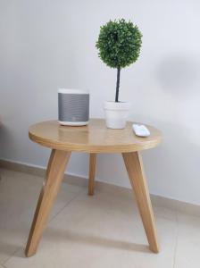 a wooden table with a potted plant on top of it at Apartasol confortable cerca al parque del café! in La Tebaida