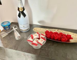 una mesa con un plato de rosas rojas y una botella de vino en B&B Cloe, en Scafati
