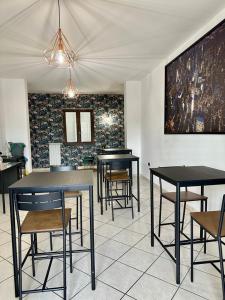 een kamer met zwarte tafels en stoelen en een muur bij B&B Cloe in Scafati