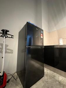 a black refrigerator in a kitchen with a camera at Be Right Back Homestay in Bukit Mertajam