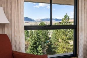 um quarto com uma grande janela com vista para as árvores em Denver Marriott West em Golden