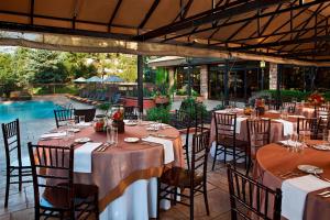 un restaurante con mesas y sillas y una piscina en Denver Marriott West en Golden