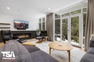 a living room with a couch and a fireplace at Chalet 26 in Thredbo
