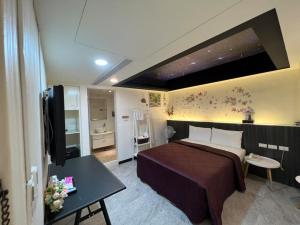 a hotel room with a bed and a television at Joy Garden Hotel in Kaohsiung
