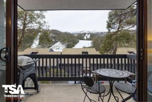 a balcony with a table and chairs and a view at Mowamba B2 in Thredbo