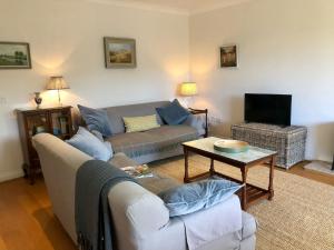 a living room with a couch and a table at 1A Erneston Crescent in Corsham