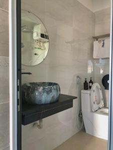 bagno con lavandino, specchio e servizi igienici di Thiên Các Hotel a Quy Nhon