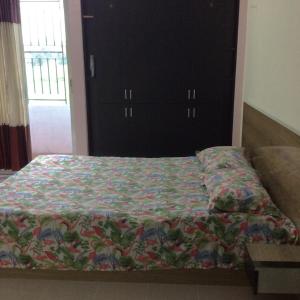 un letto con una trapunta in una camera da letto di ApartmenT - Homestays a Sylhet