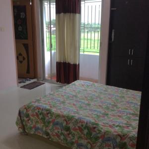 una camera con un letto in una stanza con una finestra di ApartmenT - Homestays a Sylhet