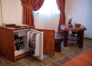 a small refrigerator in a room with a table at Gardoš rooms in Zemun